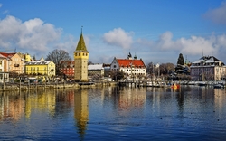 Historische Gebäude und ein Turm am Ufer eines Sees.